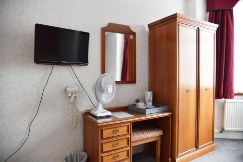 剑桥Crystal Hotel & Savour的客房设有带镜子的书桌和电视。
