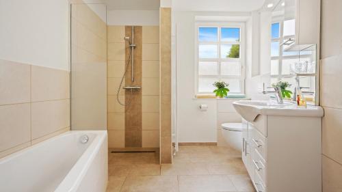 旺格兰Hotel Deichinsel的带浴缸、盥洗盆和卫生间的浴室