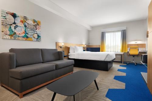LachuteMicrotel Inn & Suites by Wyndham Lachute的酒店客房设有一张沙发和一张床