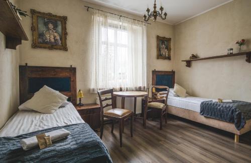 耶莱尼亚古拉-雅戈尼昂库夫Stara Willa的带两张床和一张桌子的房间以及一间用餐室