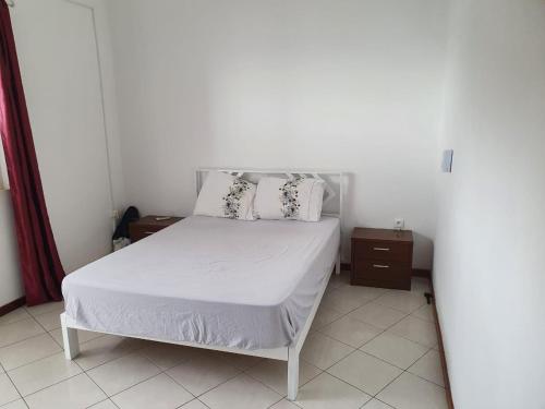 TarrafalSeaview Apartment的卧室配有白色的床和2个枕头