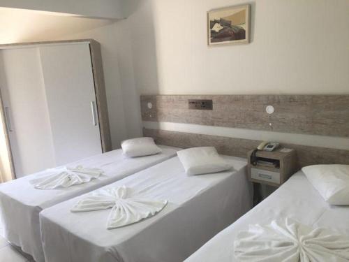 伊瓜苏Hotel AVM的配有镜子的客房内的2张白色床