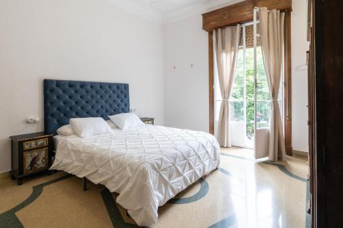 奥伦塞Casa Bogart的一间卧室配有一张带蓝色床头板的床和窗户
