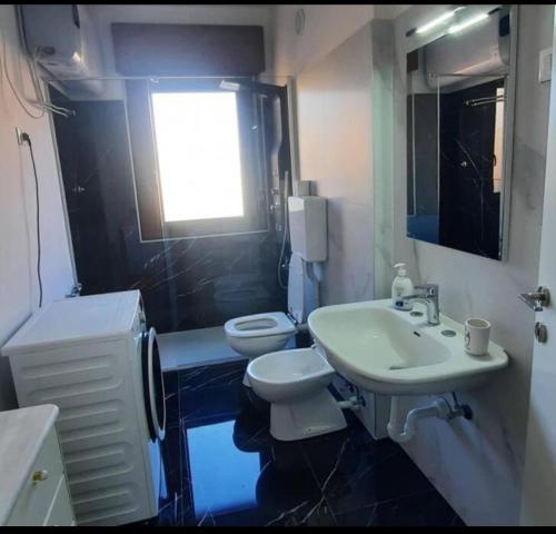 特伦托Verdisuite - Trento centro - Parcheggio privato gratuito的一间带水槽和卫生间的浴室以及窗户。