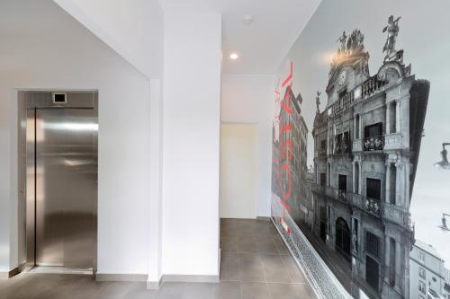 潘普洛纳IRAIPE Pamplona Hostal的墙上有一栋建筑的照片的房间