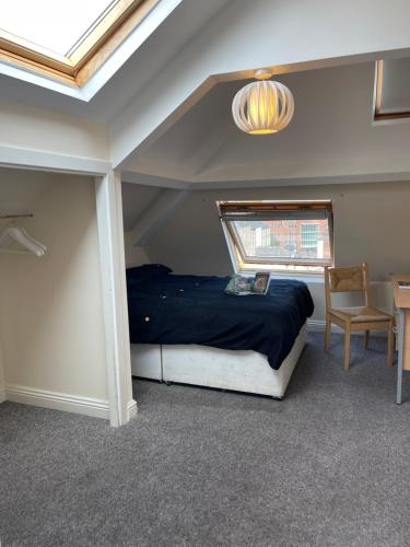 泰恩河畔纽卡斯尔Cosy Room in city centre的一间卧室设有一张床、一个窗口和一张桌子