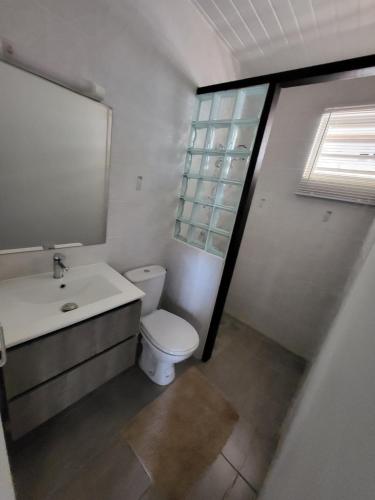 MatouryLocaGuyane的一间带卫生间、水槽和窗户的浴室