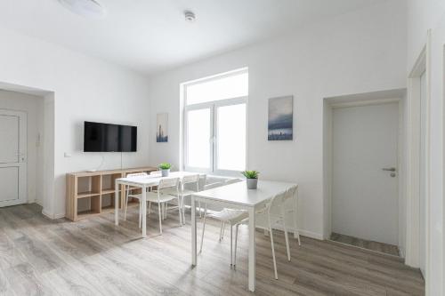 杜伊斯堡T&K Apartments - 1 to 4 Room Apartments - 20min to TradeFair Messe Airport Düsseldorf的白色的客房配有桌椅和电视