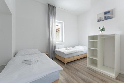 杜伊斯堡T&K Apartments - 1 to 4 Room Apartments - 20min to TradeFair Messe Airport Düsseldorf的白色的客房设有两张床和窗户。