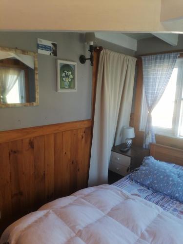 埃尔基斯科Habitación tipo Loft de la Estancia的一间卧室配有一张床、镜子和窗户