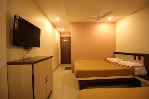 舍地Hotel Sai Balaji的小房间设有两张床和一台平面电视