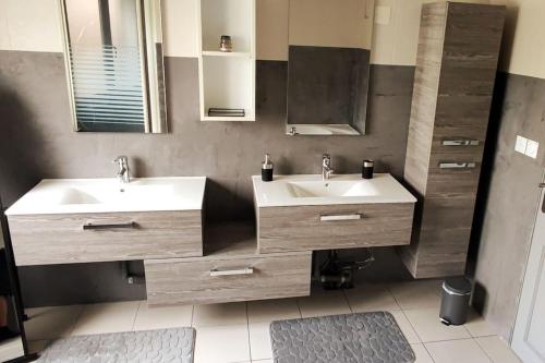 拉布雷斯Maison Gite Le Bressaud的浴室设有2个水槽和镜子