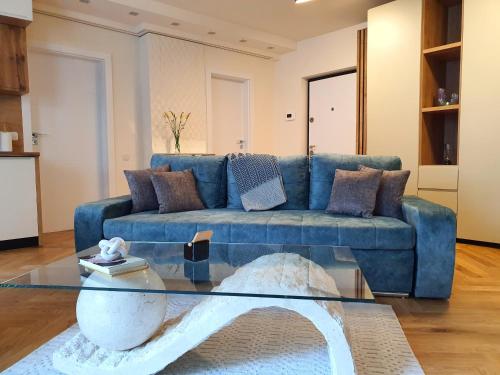 克卢日-纳波卡Lavish Inn Apartment的客厅配有蓝色沙发,设有玻璃桌