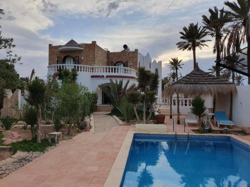 Al MaqārisahMille & une nuit的一座房子前面设有游泳池