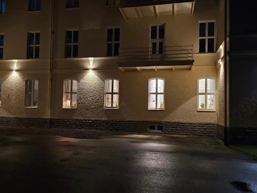 AxvallStora Ekeberg vandrarhem的一座晚上有窗户的建筑,灯光照亮