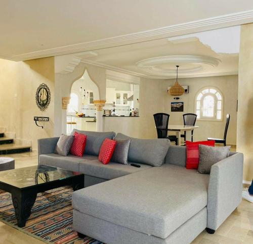 Al MaqārisahMille & une nuit的客厅配有灰色沙发和红色枕头