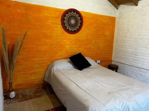 卢汉德库约RAMA GUEST HOUSE- COMPLEJO ENTERO- LUJAN DE CUYO- CACHEUTA- MONTAÑA DE Mendoza-Argentina的一间卧室配有一张带黑色枕头的床