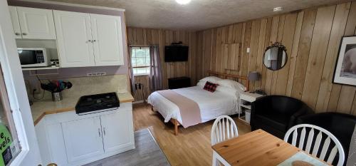 DwightParkway Cottage Resort and Trading Post的一间卧室配有一张床,厨房配有桌子