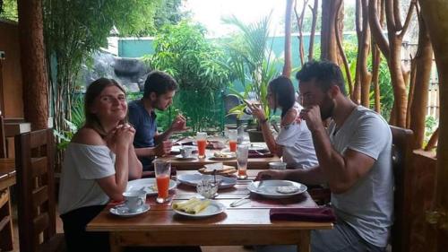 达瓦拉维Roam Wings Safari Hotel的一群坐在餐桌旁吃饭的人