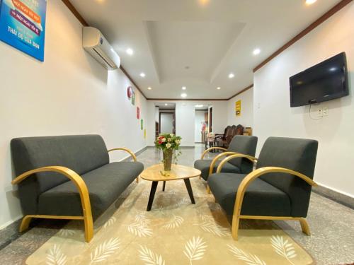 邦美蜀Căn hộ Hoàng Anh DakLak Ngay trung tâm Full nội thất 3PN thoải mái cho 8-12 người的一间设有椅子和桌子的等候室以及一台电视