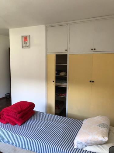 蒙得维的亚Ordeig 2223的一间卧室配有一张带红色毯子和橱柜的床。