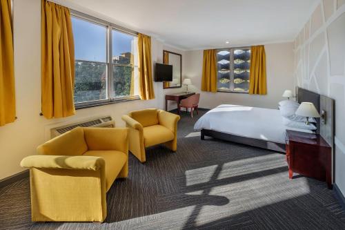 卢萨卡开罗路普罗蒂亚酒店 的酒店客房,配有一张床和两把椅子