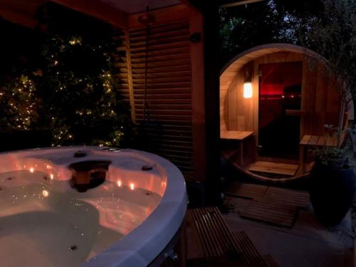 Den HamCozy villa with wellness tub sauna and garden的带浴缸的浴室和圣诞树