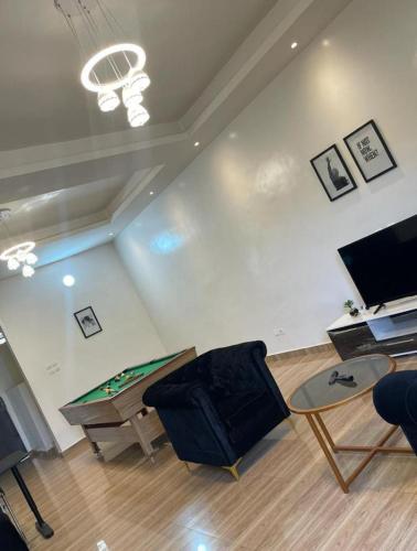 Abomey-CalaviAGIM-GUESTHOUSSE的客厅配有乒乓球桌和乒乓球桌