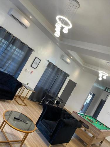Abomey-CalaviAGIM-GUESTHOUSSE的客厅配有乒乓球桌和椅子