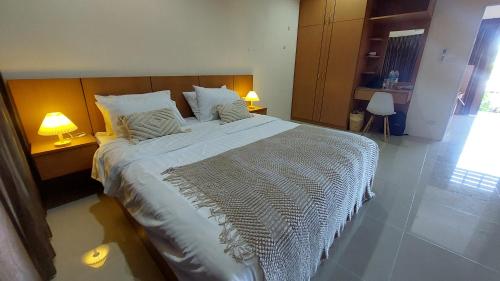 查汶Cozy Apartment Chaweng Center的卧室内的一张大床,配有两盏灯