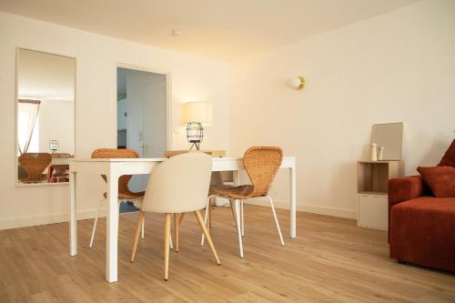 圣纳泽尔Le Rozé - Appart'Escale的一间配备有白色桌椅的用餐室