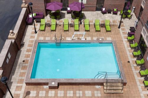 萨凡纳萨凡纳历史区假日酒店的享有带椅子和遮阳伞的游泳池的上方景色