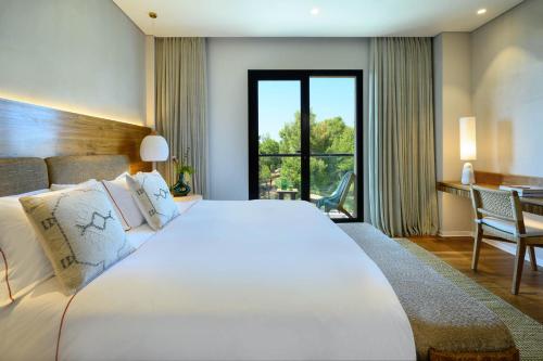萨法德Cnaan Hotel- Limited Edition By Fattal的卧室配有一张白色大床和一张书桌