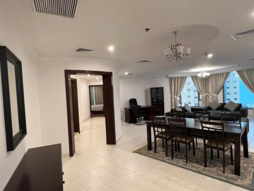 科威特Hotel Leaders Plaza Mahboula的用餐室以及带桌椅的起居室。