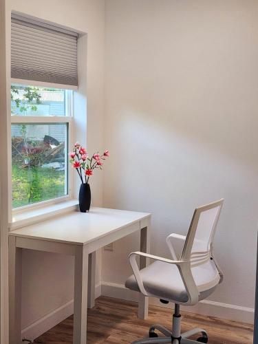 奥兰多Spacious Bedroom with private workspace, ensuite bathroom - Room# 1 in SHARED house NO PET的白色的书桌、白色的椅子和花瓶