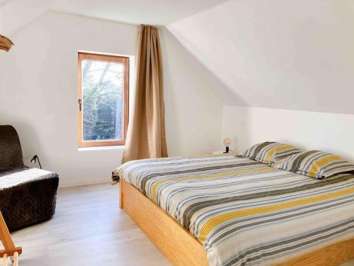 Maison Raymond - Vakantiehuisje met houtgestookte sauna的卧室配有床、椅子和窗户。