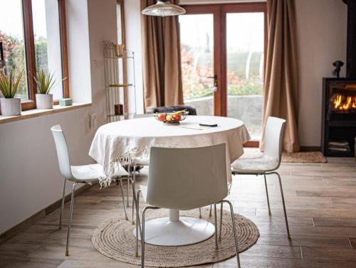 Maison Raymond - Vakantiehuisje met houtgestookte sauna的一间配备有白色桌椅的用餐室