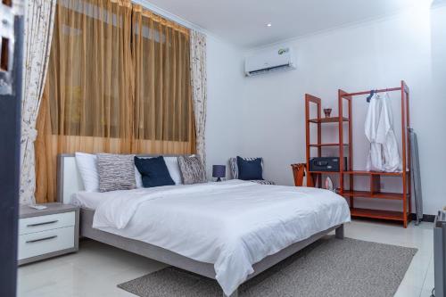 达累斯萨拉姆Upendo Boutique Hotel, Dar es Salaam的卧室配有带蓝色枕头的大型白色床