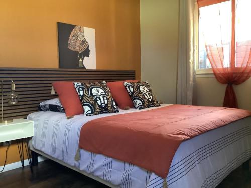 昂特尔德LE JARDIN D'HILAIRE的一间卧室配有一张带橙色墙壁和窗户的床