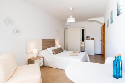 科蒂略Casa Lilia的白色卧室配有两张床和一张沙发