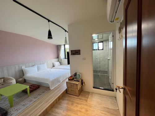 Fushi游手浩贤民宿的一间小卧室,配有一张床和一张绿桌