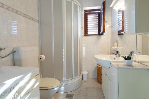 卡什泰拉Apartman Dugeč的白色的浴室设有卫生间和水槽。