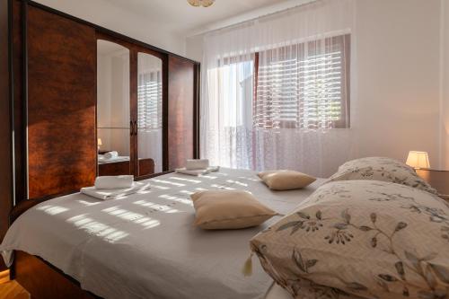 卡什泰拉Apartman Dugeč的一间卧室设有一张大床和一个窗户。