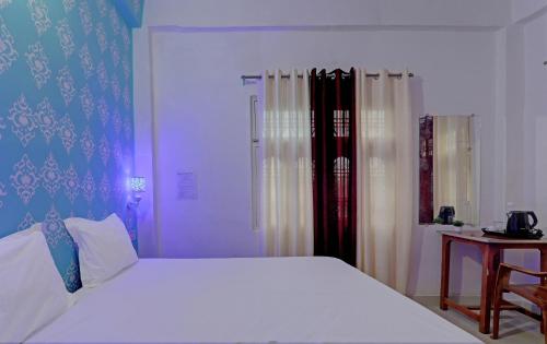 Pura RaghunāthHotel Surya Inn的卧室配有一张白色的大床和一张桌子