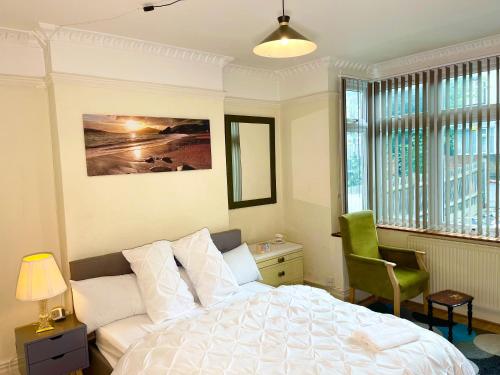 South NorwoodE-Sky Homes的卧室配有白色的床和绿色椅子