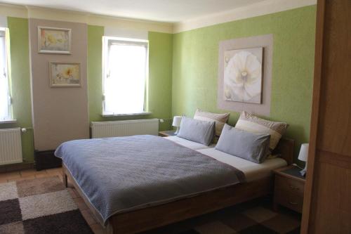 德绍Ferienunterkünfte Familie Berger的一间卧室设有一张带绿色墙壁的大床