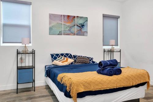 洛杉矶Hollywood 3BR home near metro的一间卧室配有一张带蓝色床单和窗户的床。