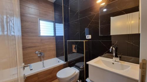 Bene BeraqNew Stylish Apartment with Balcony Close to Tel Aviv的浴室配有卫生间、盥洗盆和浴缸。