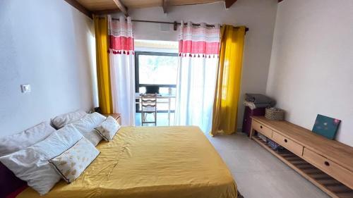 穆龙达瓦Harena Villa的一间卧室设有一张黄色的大床和一扇窗户。