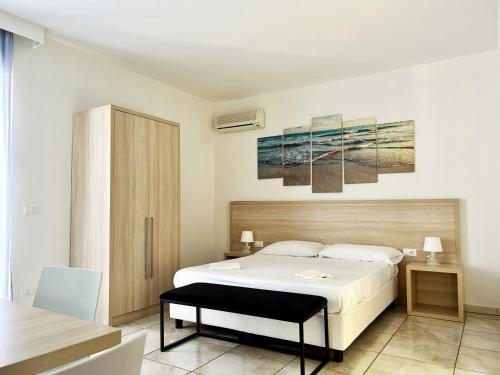 罗萨诺Resort Park Village的卧室配有一张白色的大床和一张桌子